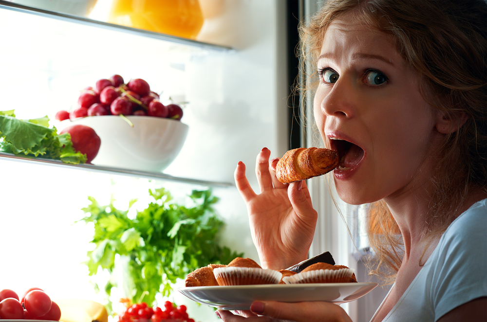 žena jede iz frižidera