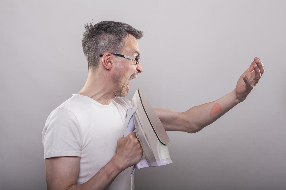 A man burned his hand with a hot iron