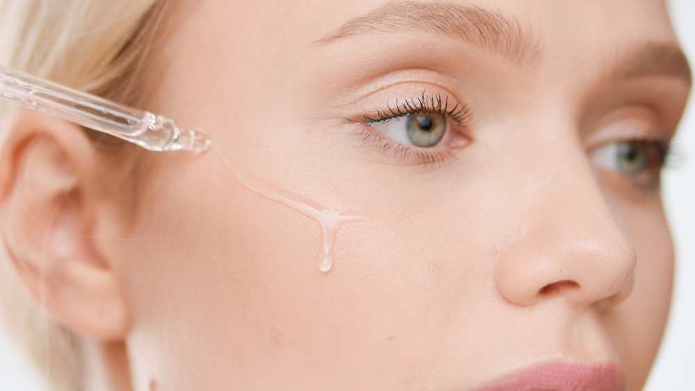 A woman applying serum on skin