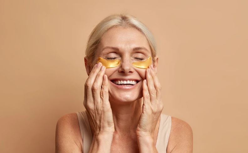 woman applying golden undereye patches